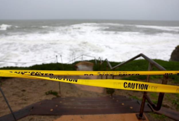 Caution tape blocks an access stairway toward the Pacific Ocean in Santa Cruz, Calif.