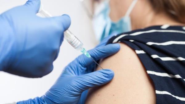 Closeup of medical worker's hands in blue protective gloves injecting vaccine booster shot into elderly patient's shoulder,Coro<em></em>navirus vaccination against COVID-19 virus disease,immunity certificate