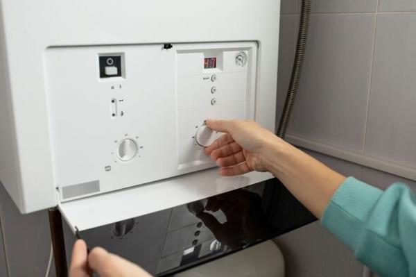 A woman reduces the power of the gas boiler in her home due to an energy crisis