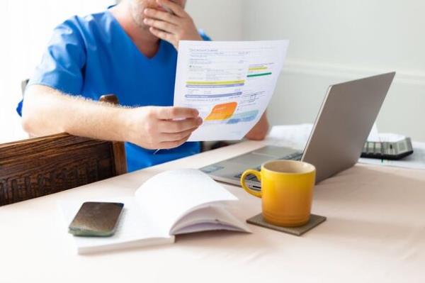 Male nurse checking energy bills at home