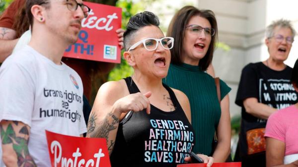 Gwenn Mangine of Cary, center, and others participate in a rally opposing HB 574 and SB 631 outside the NC Legislative building Thursday, April 20, 2023. House Bill 574 bans transgender athlete participation in women’s sports in middle, high school and college.