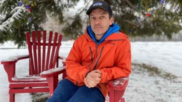 man sits in chair surrounded by snow