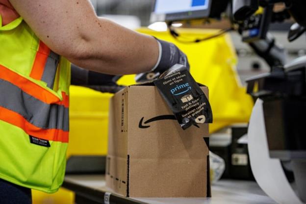 A worker adds a label to a shipment box in a warehouse.