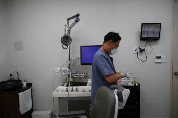 Pediatrician Song Jong-geun gets ready at his clinic in Seoul on June 14. 