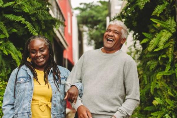 Man and woman walking arm and arm and laughing