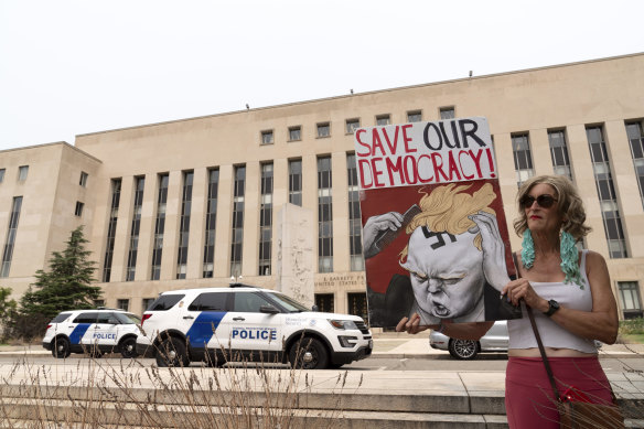 Voter Nicky Sundt holds a banner outside the Federal District Court.