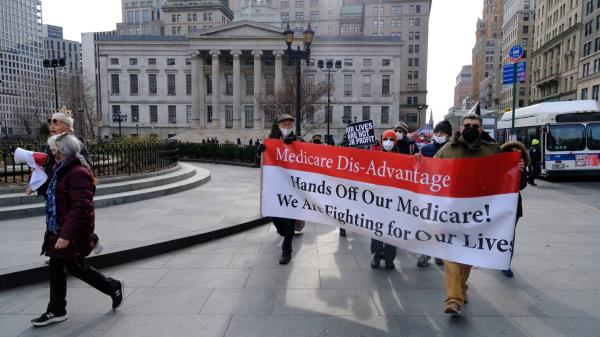 Retired city workers are pictured marching near Brooklyn Borough Hall to call on Mayor-elect Adams to preserve their Medicare coverage.