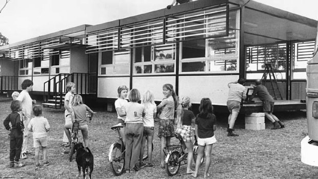 Children watch workmen move a new demountable classroom block into position at Charlestown East Primary School. 