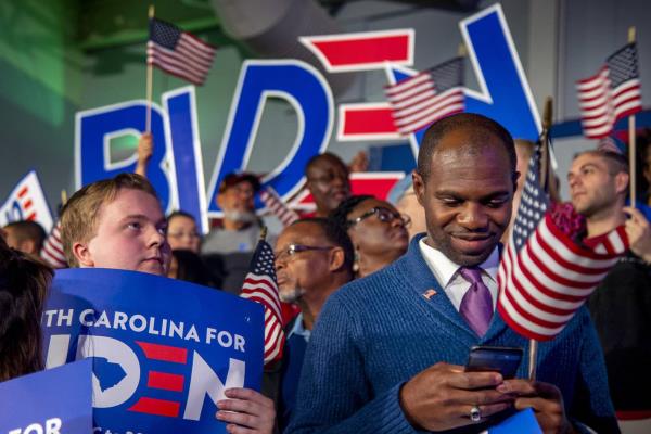 Will Cokley, from Charlotte, N.C., checks his phone for the results of the South Carolina Democratic primary, during a Joe Biden election night victory party in Columbia, S.C., Feb. 29, 2020. 