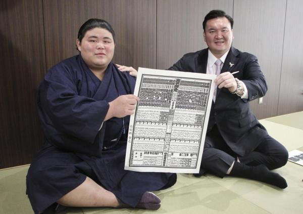 Hakuoho (left) and his mentor, former yokozuna Hakuho, display the sumo rankings chart ahead of the Nagoya tournament, in Toyota, Aichi Prefecture, on Monday. | KYODO