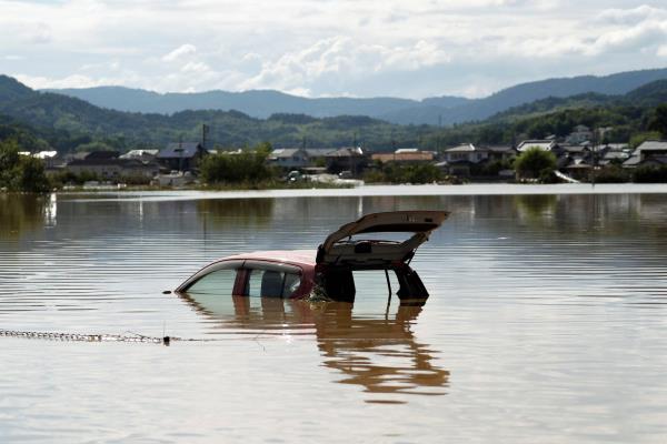 A car is submerged in a flooded area of Kurashiki, Okayama Prefecture, in 2018. As the climate warms, mountainous regions will get more extreme rainfall than previously thought, and more of the dangers that come with it, according to a study published on Wednesday, in the journal Nature. 