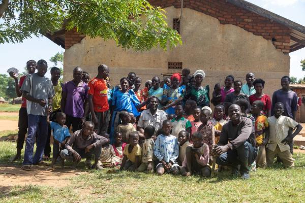 Musa Hasahya, center, poses for a picture with some of his wives, children and grandchildren outside their family home in Butaleja district in Eastern Uganda, on Jan. 17, 2023.