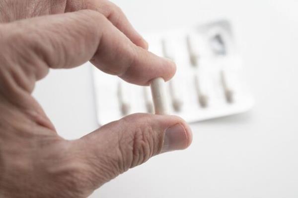 A hand holding antibiotic pills